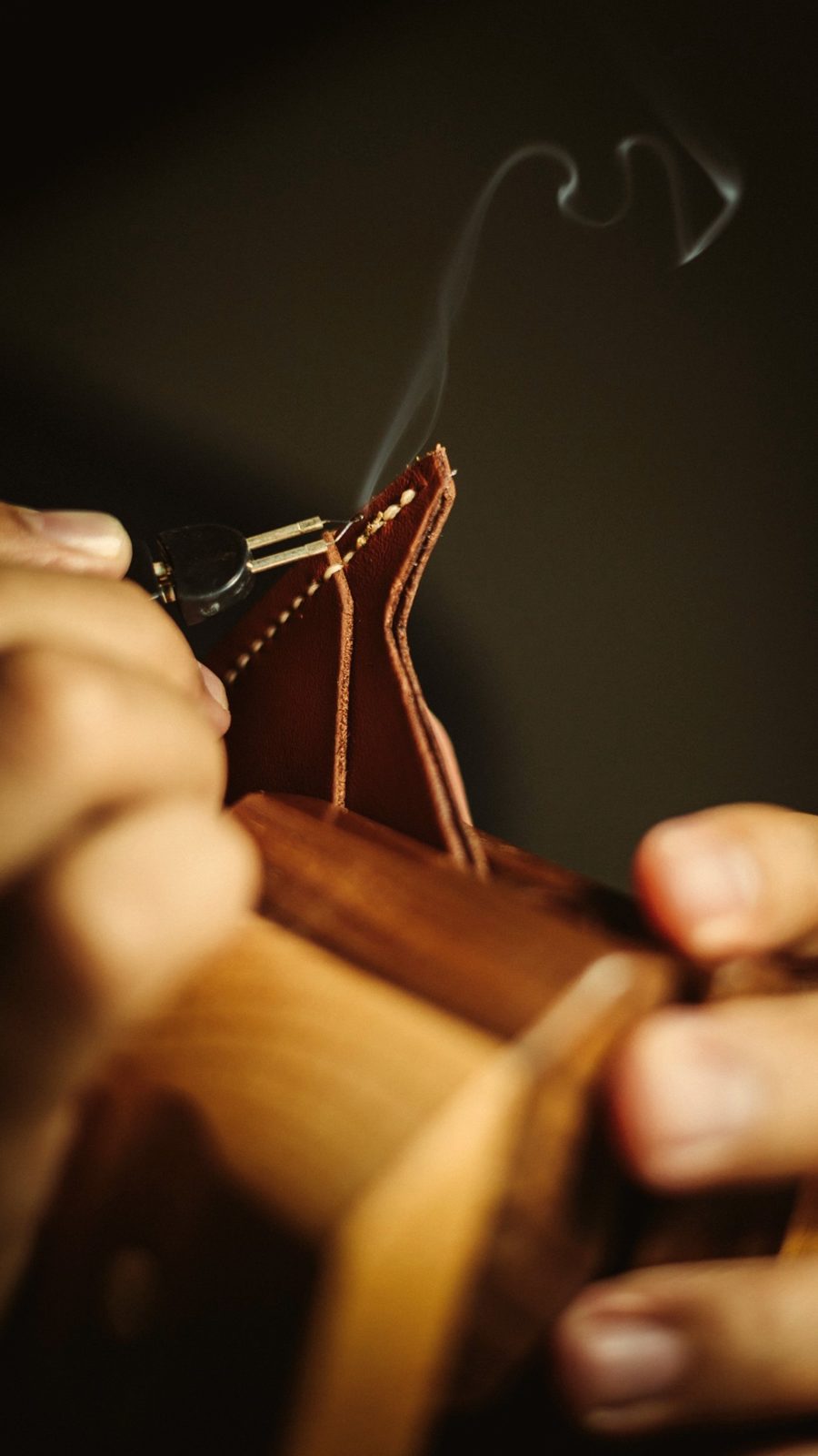 Craftsman hand-stitching a leather wallet